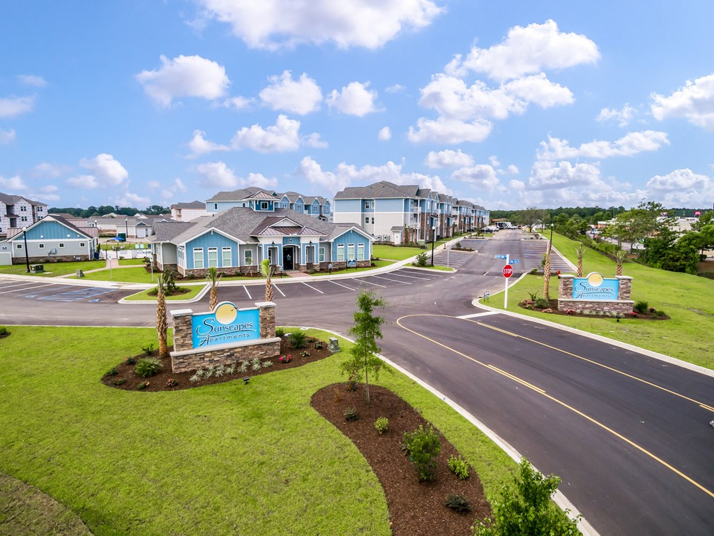 a street with houses on either side and a blue sky in the background
