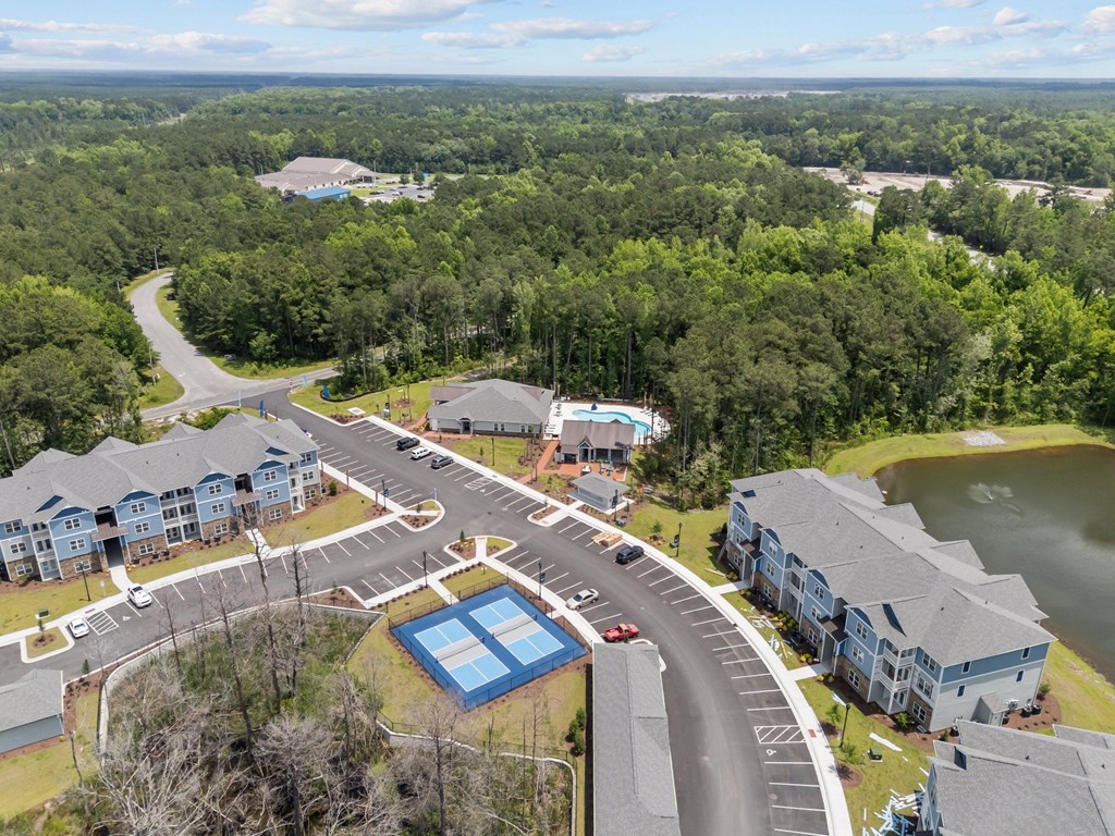 A bird's eye view of a residential area with a roundabout and swimming pool.