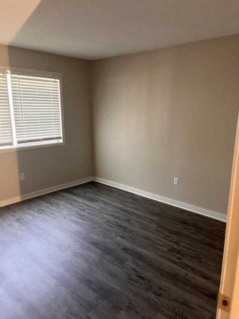 an empty room with wooden floors and a window