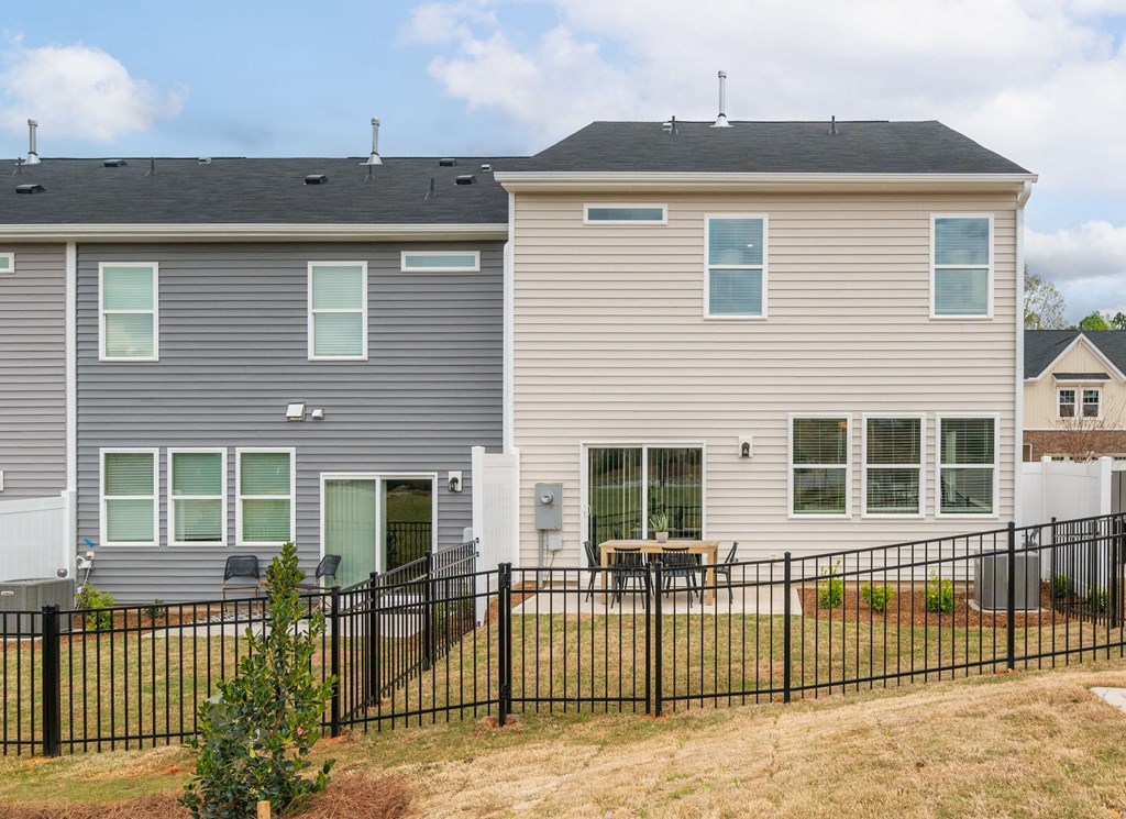 the back of a house with a fence in front of it