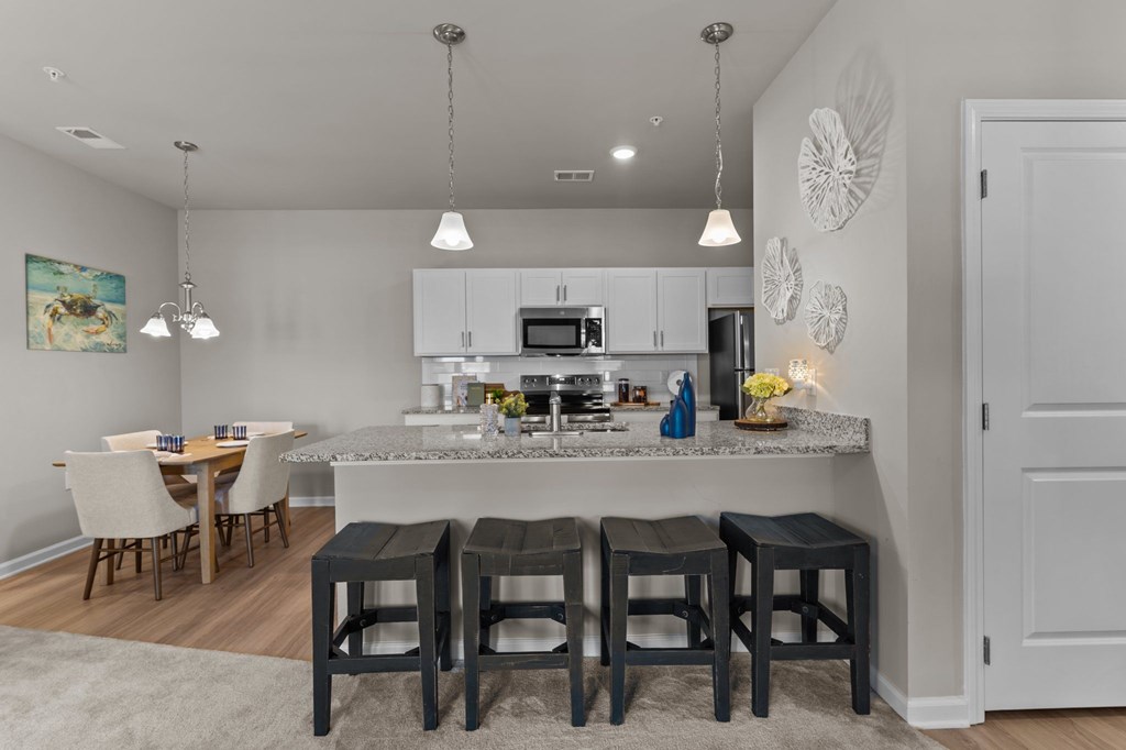A kitchen with a bar stool in front of the counter.