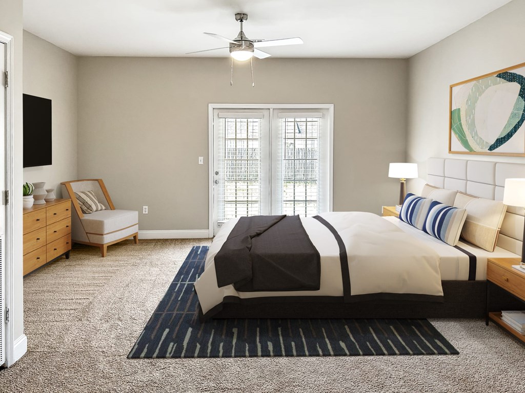 A bedroom with a large bed and a ceiling fan.