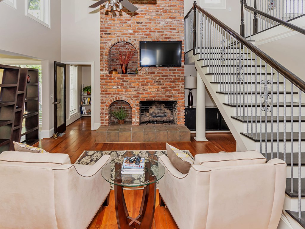 A living room with a fireplace and a television above it.