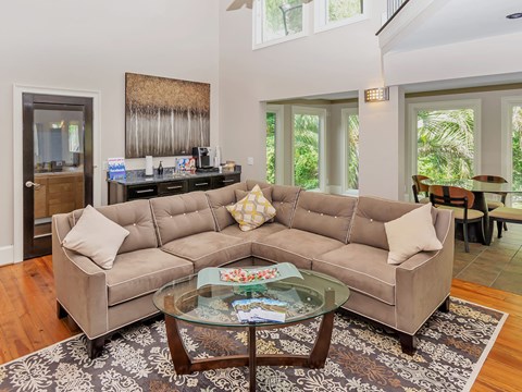 A living room with a large sectional sofa and a glass coffee table.
