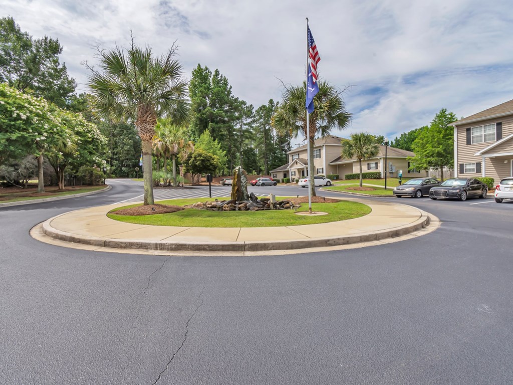 A roundabout with a flag in the middle of a residential street.