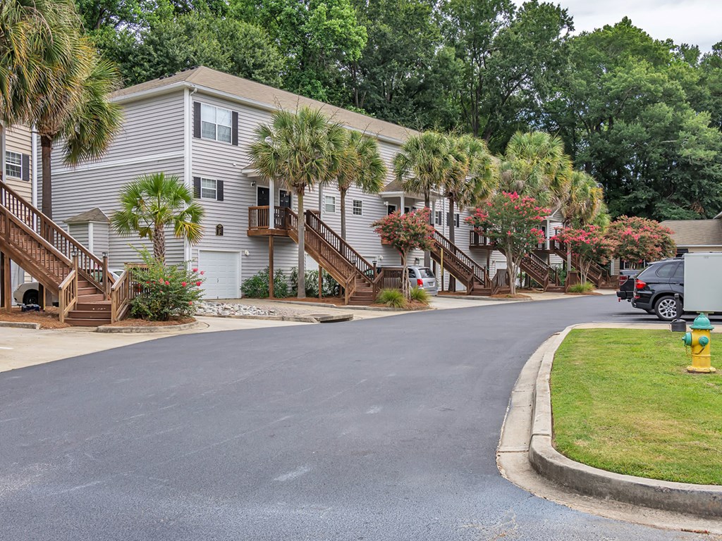 A residential street with houses and a parked car.