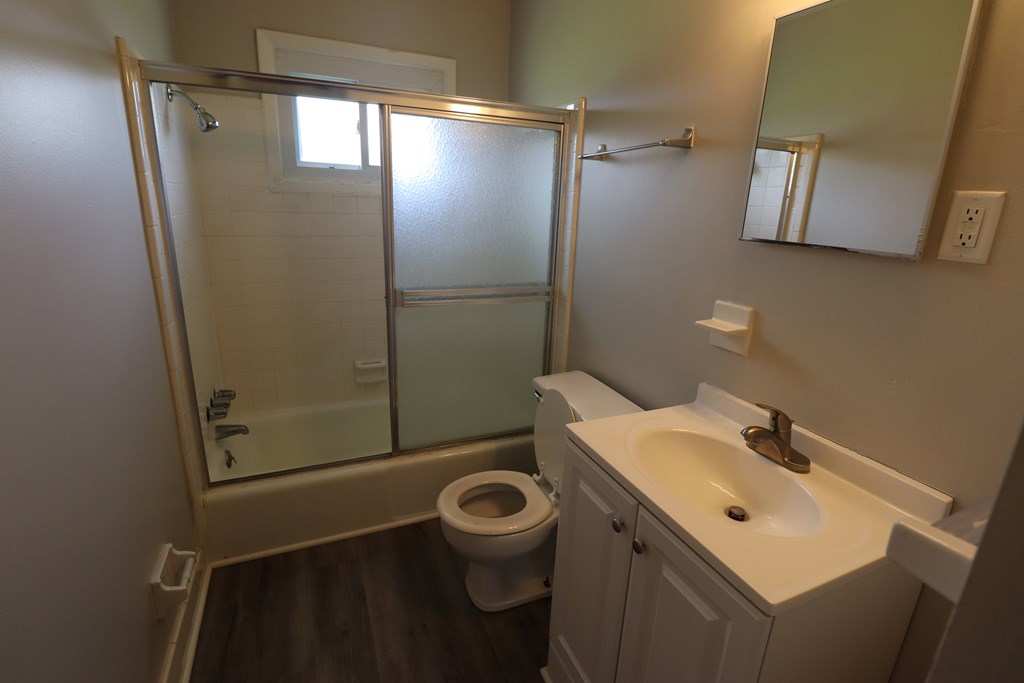 A bathroom with a toilet, sink, and shower.