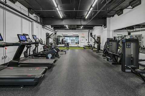 A spacious gym with treadmills, elliptical machines, and other exercise equipment.