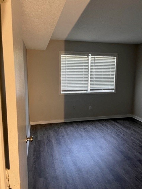 an empty room with wood floors and a window