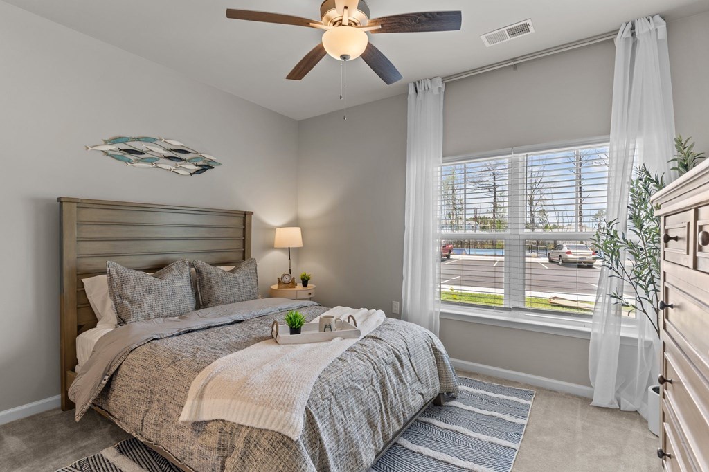A bedroom with a large bed and a ceiling fan.