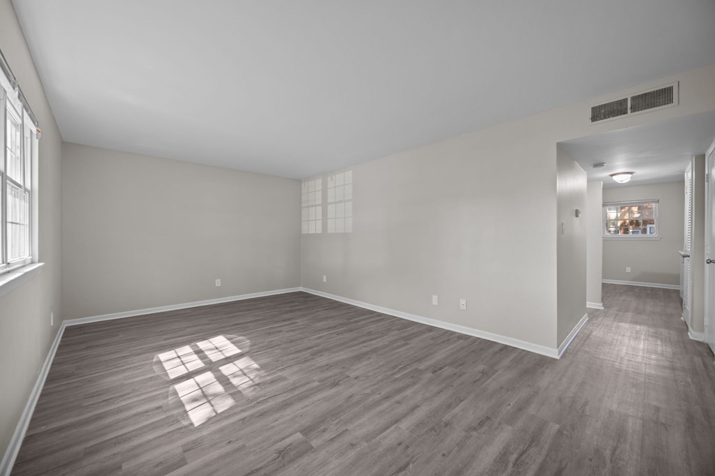A room with wooden flooring and white walls.