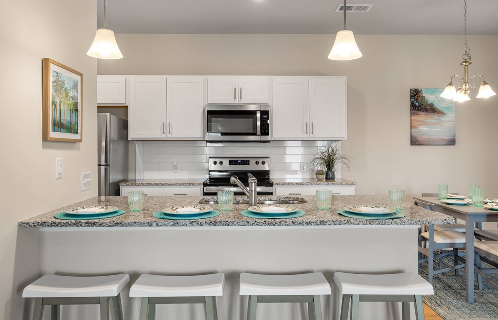 a kitchen with white cabinets and a granite counter top