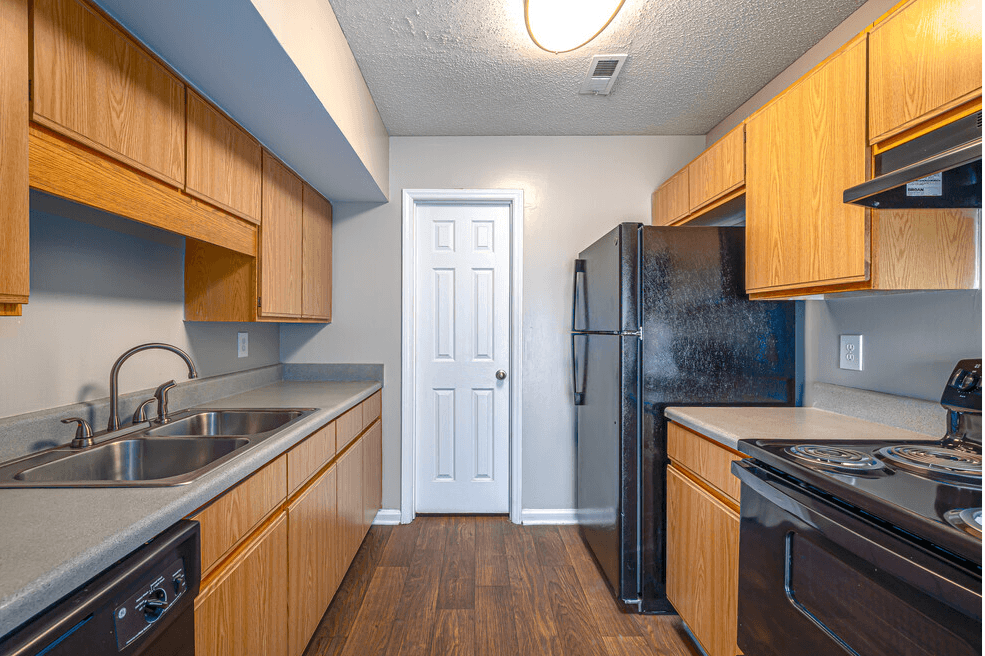 a kitchen with wooden cabinets and a black refrigerator