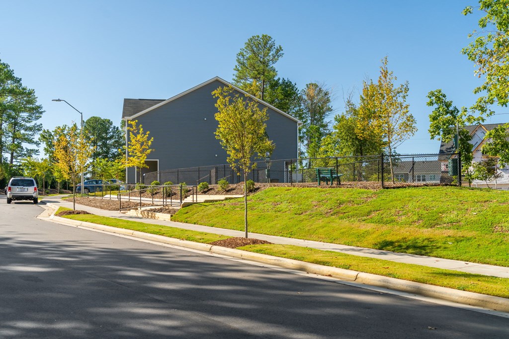a building on the side of a street with trees and a sidewalk