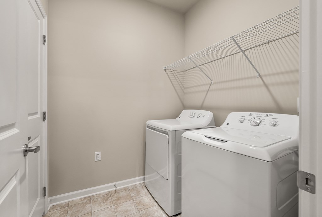 a washer and dryer in the laundry room at the enclave at woodbridge apartments in