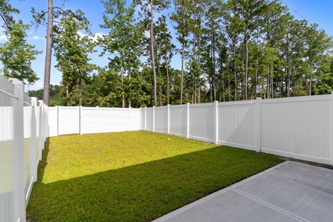 A white fence encloses a green yard.