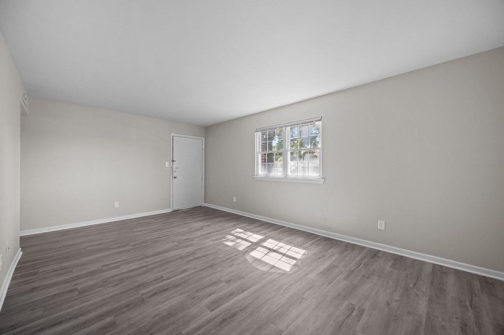 A room with a window and wooden flooring.