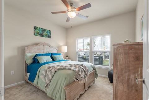 a bedroom with a bed and a ceiling fan