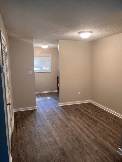 an empty room with a hard wood floor and a window