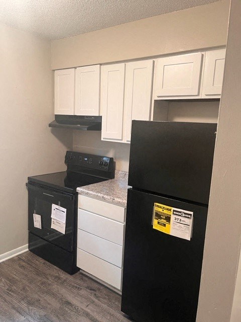 a kitchen with a refrigerator and a stove and cabinets