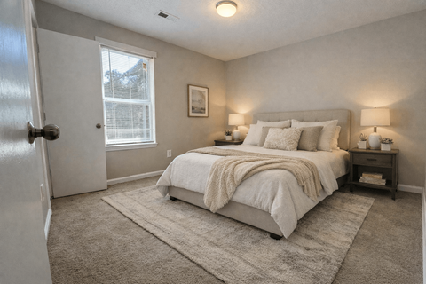 A bedroom with a large bed and a window.