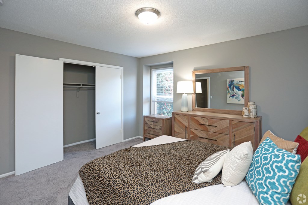 a bedroom with a bed and a closet and a mirror