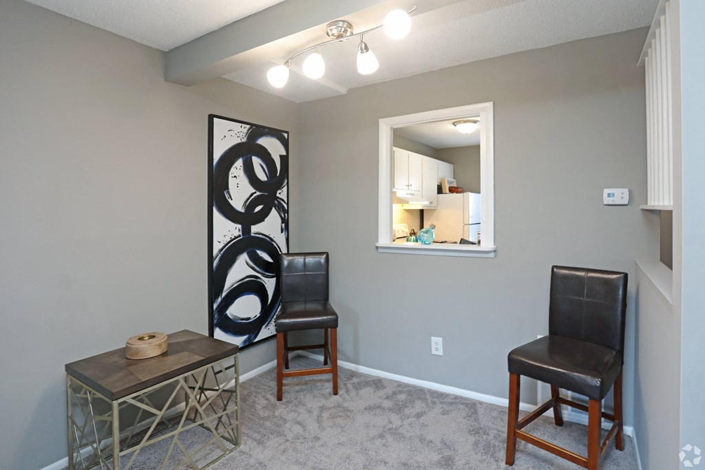 a living room with two chairs and a table and a mirror
