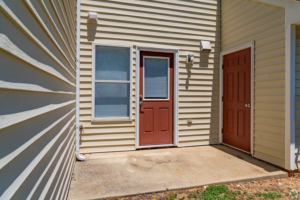 A house with a brown door and a window with blinds.