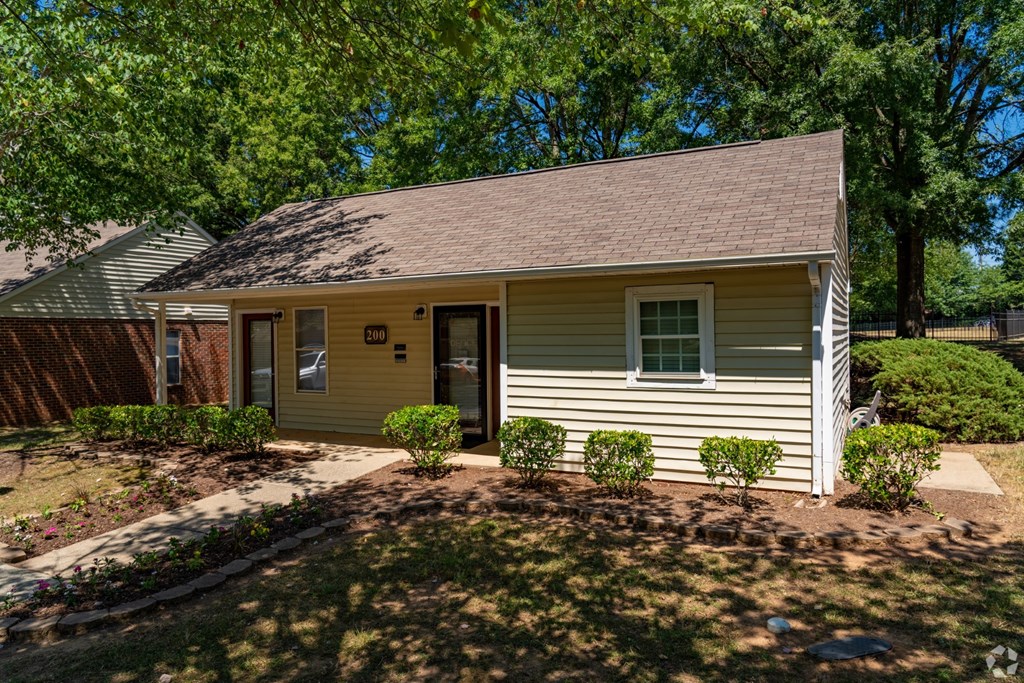 A small house with a brown roof and a yellow door.