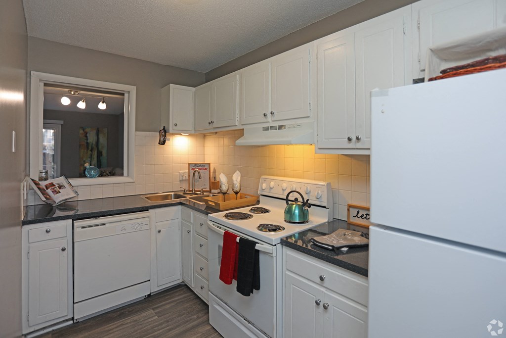 a kitchen with white cabinets and a stove and a refrigerator