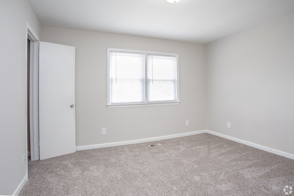 an empty room with carpet and a window