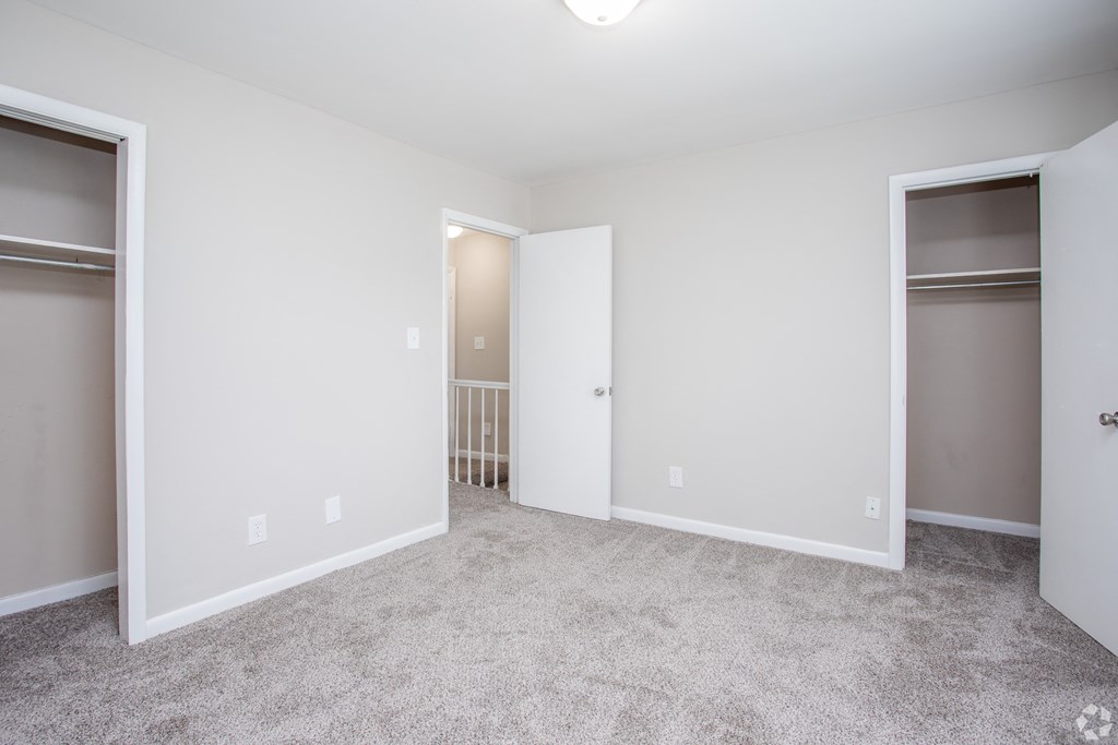 Empty room with white walls and carpeted floor.