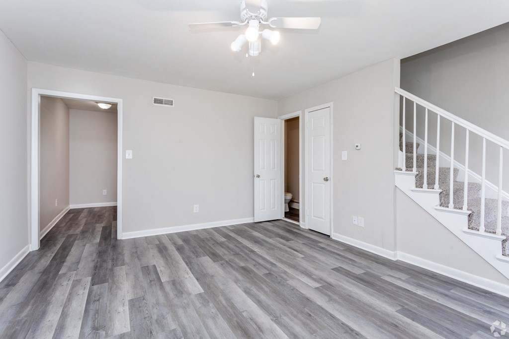 A room with a staircase and a ceiling fan.