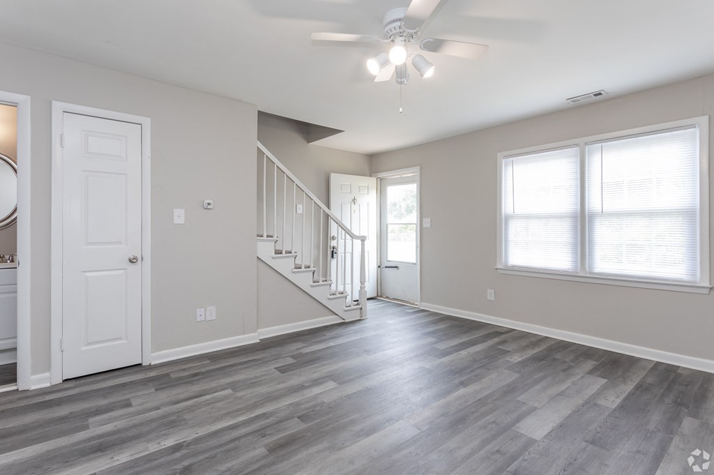 A spacious room with a staircase leading to the second floor.
