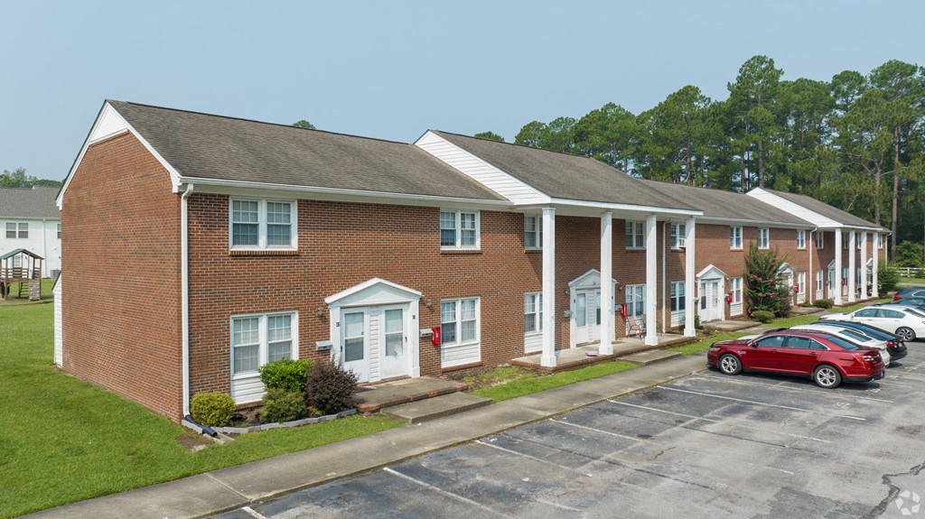 a red brick building with cars parked in front of it