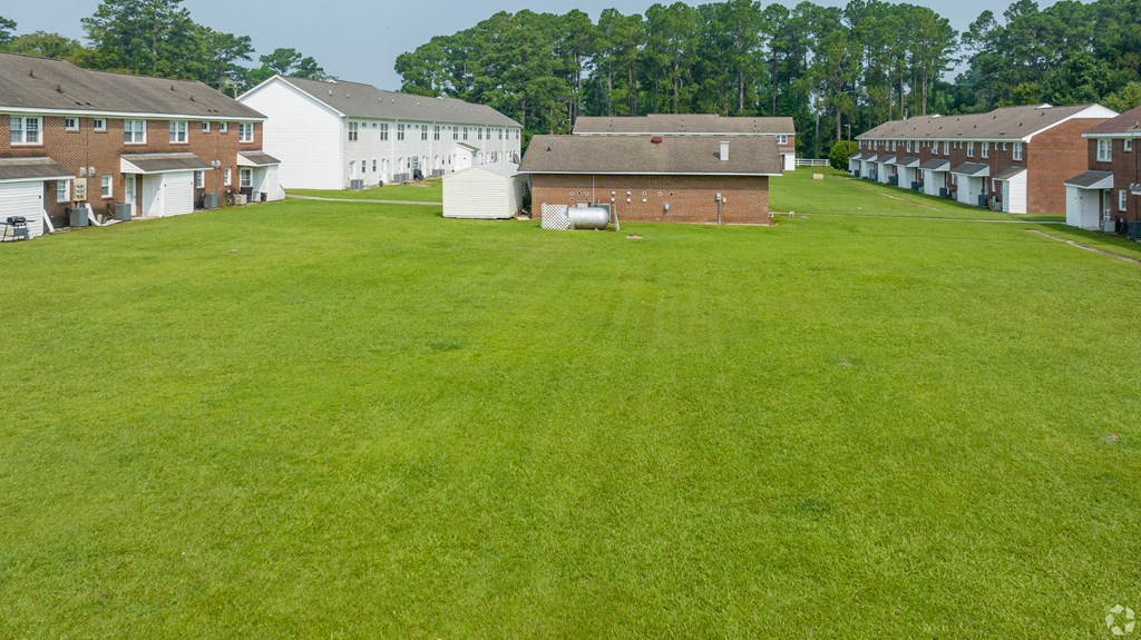 a large lawn in front of a row of houses