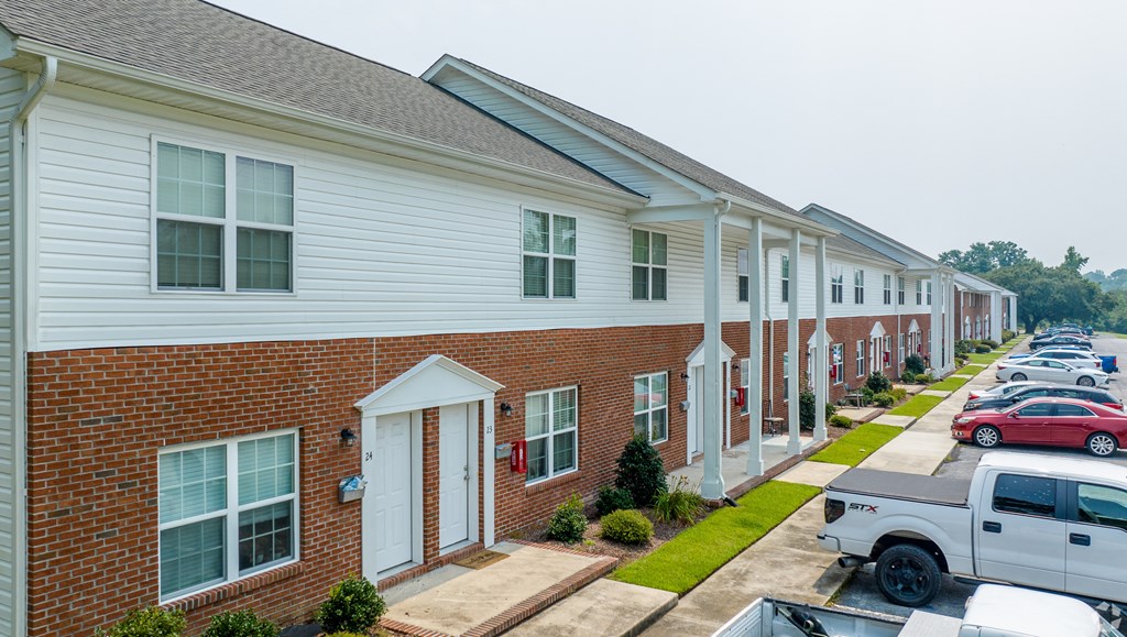 a row of townhomes with cars parked in front of them