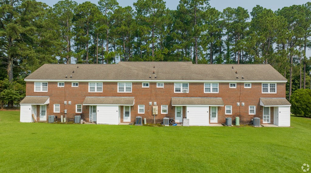 a large brick house on a green lawn