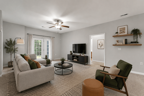 A living room with a grey couch, a green chair, a coffee table, and a flat screen TV.