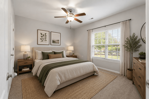 A bedroom with a large bed and a ceiling fan.