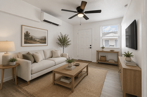 A living room with a white couch, a wooden coffee table, a ceiling fan, and a painting on the wall.