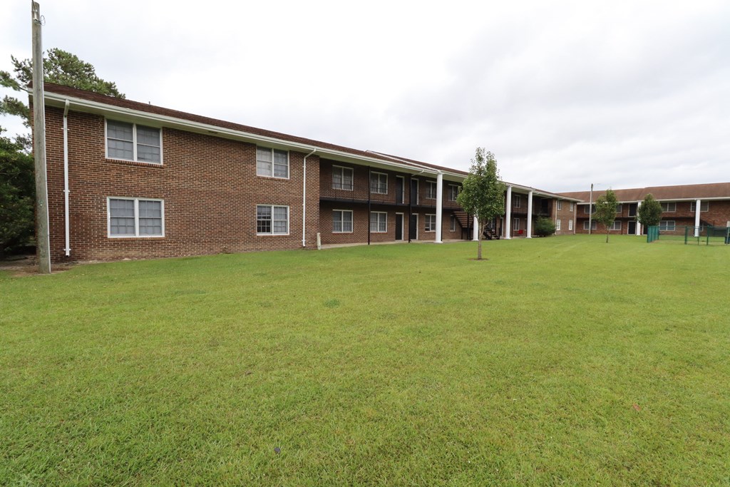a large green lawn in front of a brick building