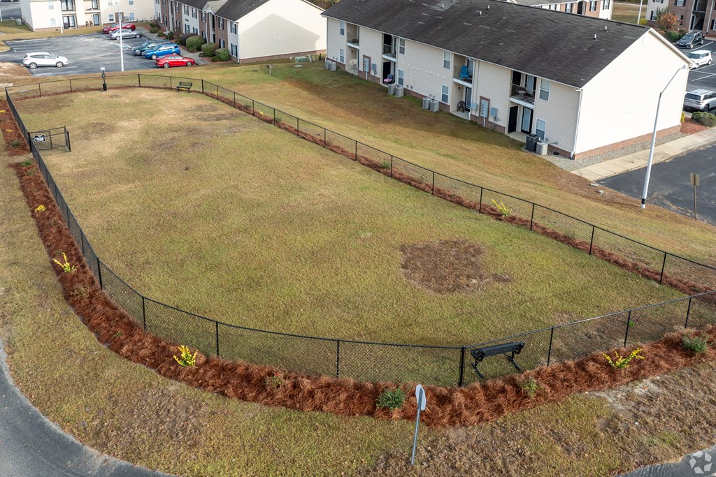 A park with a baseball diamond and a fence.
