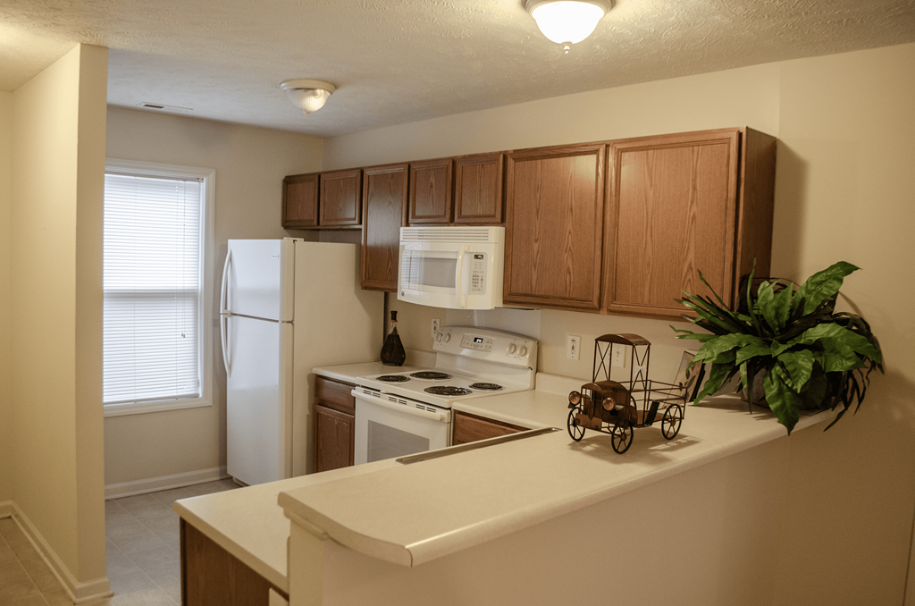 a kitchen with white appliances and wooden cabinets