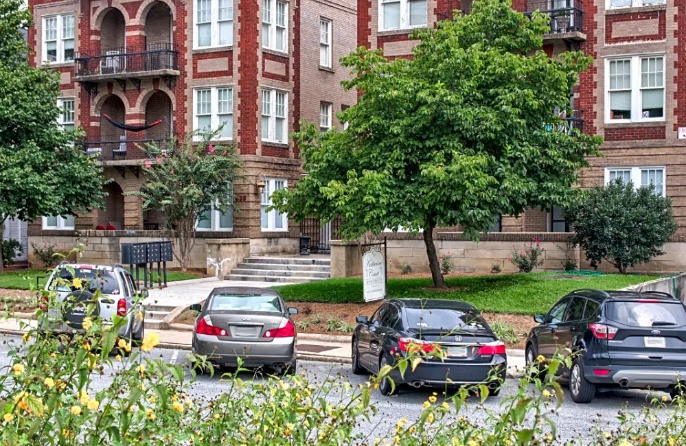 a group of cars parked in a parking lot in front of a building