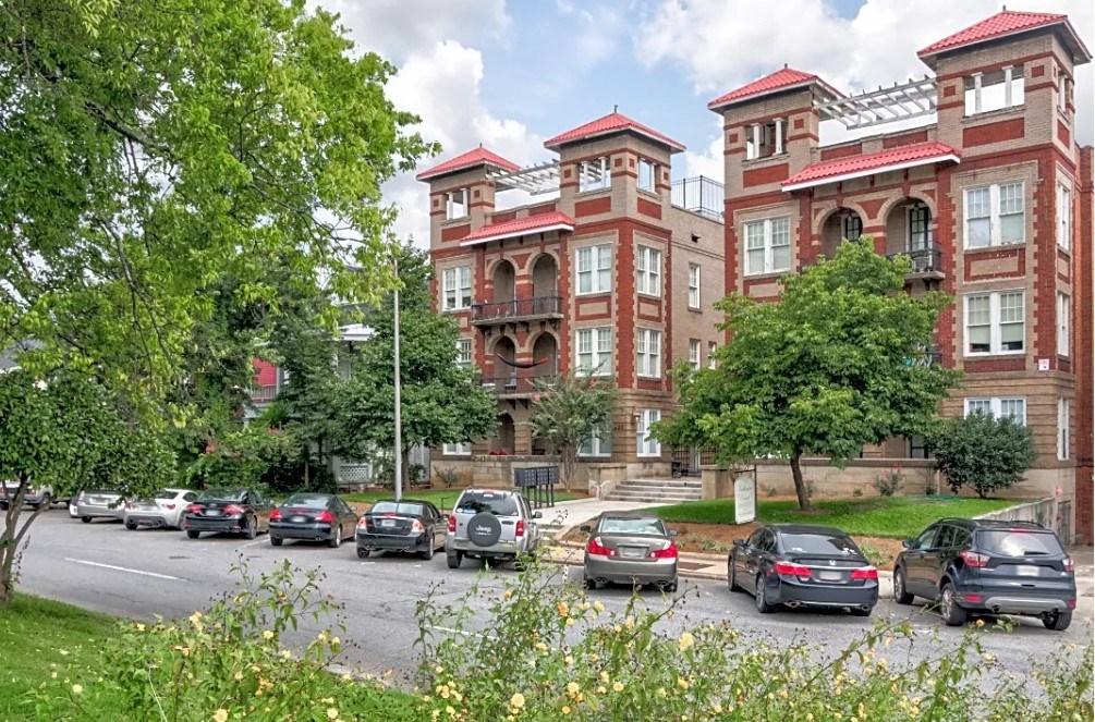 the apartment building has many cars parked in front of it
