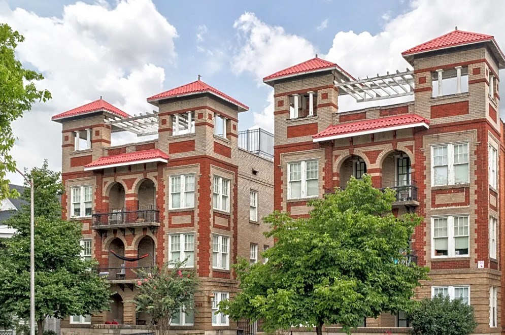a group of three brick buildings with trees in front of them