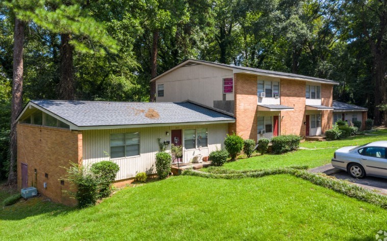 a house with a yard and a car parked in front of it