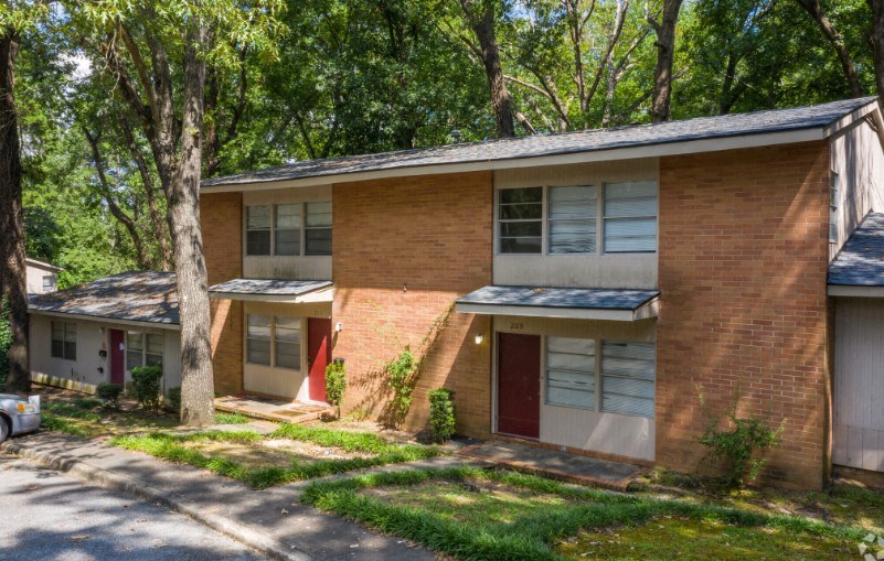 the front of a brick house with trees