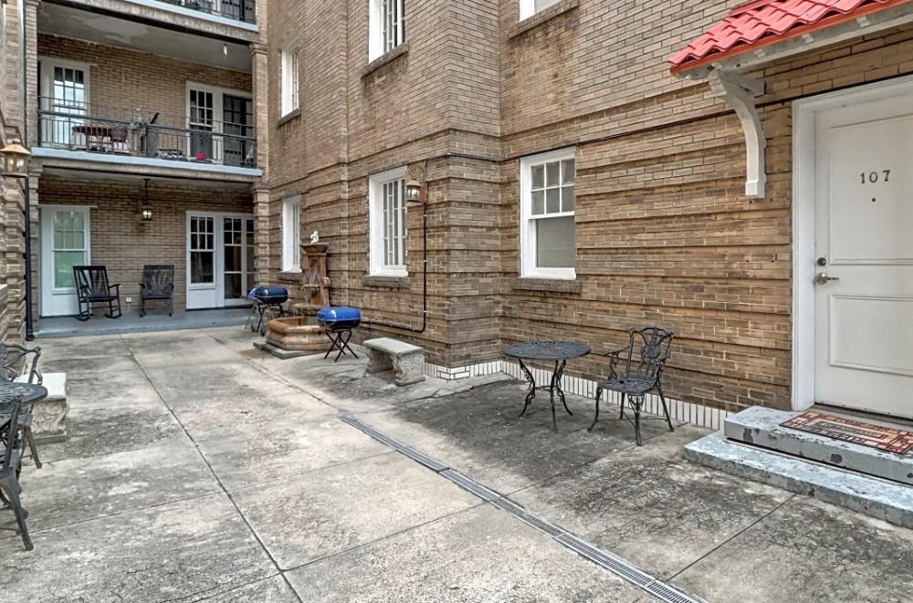 the outside of a house with a patio and chairs